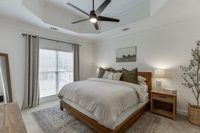 bedroom featuring visible vents, a tray ceiling, ornamental molding, and light colored carpet