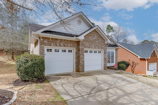 view of front of house with driveway, an attached garage, a shingled roof, and brick siding