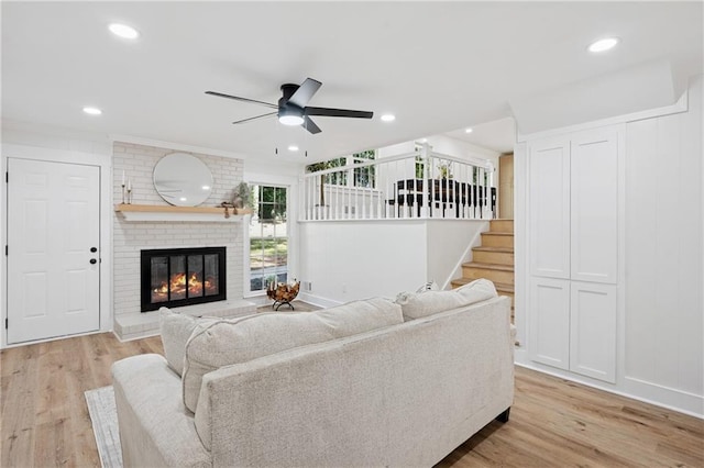 4745 Elam Forest Dr, Stone Mountain, GA 30083 - living room featuring a ceiling fan, a brick fireplace, stairway, light wood-style flooring, and recessed lighting