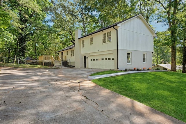 4745 Elam Forest Dr, Stone Mountain, GA 30083 - view of front facade featuring an attached garage, concrete driveway, a chimney, a front yard, and a deck