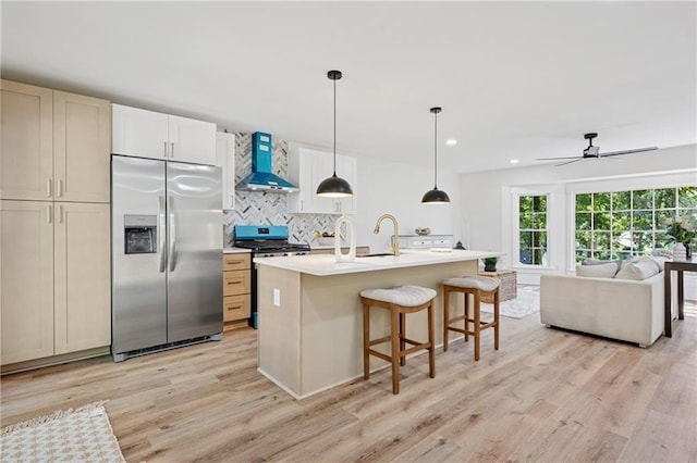 4745 Elam Forest Dr, Stone Mountain, GA 30083 - kitchen with appliances with stainless steel finishes, wall chimney range hood, light wood-type flooring, decorative backsplash, and open floor plan