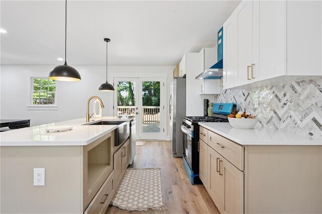 4745 Elam Forest Dr, Stone Mountain, GA 30083 - kitchen featuring appliances with stainless steel finishes, a sink, light wood finished floors, an island with sink, and decorative backsplash