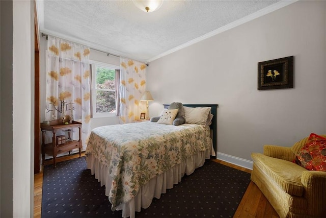 bedroom featuring crown molding, a textured ceiling, wood finished floors, and baseboards