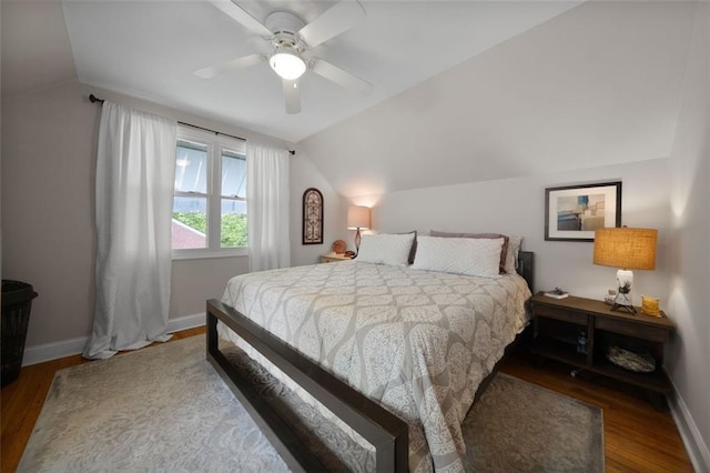 bedroom featuring a ceiling fan, wood finished floors, lofted ceiling, and baseboards