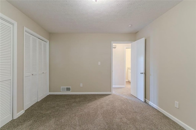 545 Fayetteville Rd, Fairburn, GA 30213 - unfurnished bedroom with carpet floors, two closets, a textured ceiling, and baseboards
