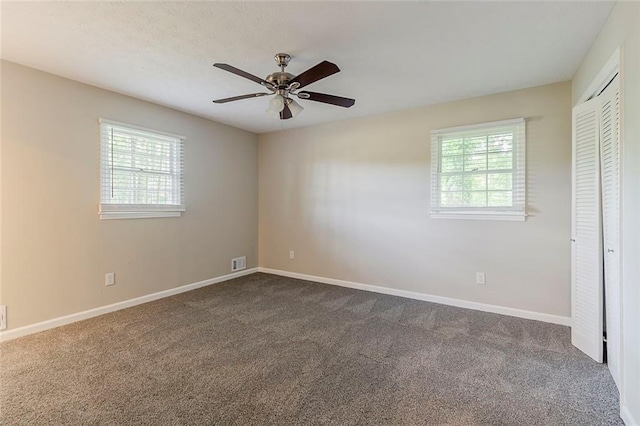 545 Fayetteville Rd, Fairburn, GA 30213 - unfurnished bedroom with multiple windows, dark carpet, a closet, and baseboards