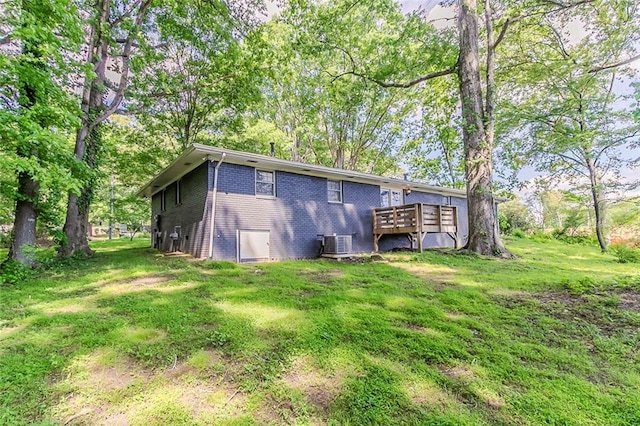 545 Fayetteville Rd, Fairburn, GA 30213 - back of property with brick siding, a wooden deck, a lawn, and central AC