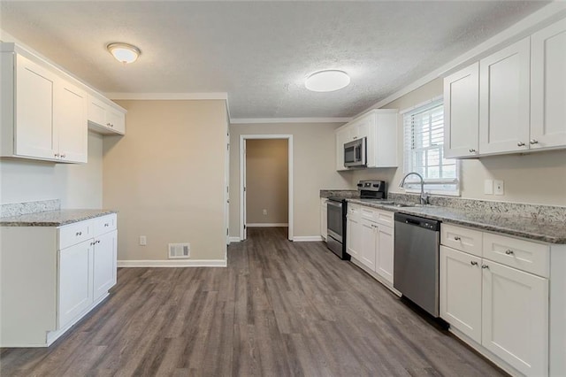 545 Fayetteville Rd, Fairburn, GA 30213 - kitchen featuring appliances with stainless steel finishes, a sink, dark wood-style floors, white cabinetry, and a textured ceiling