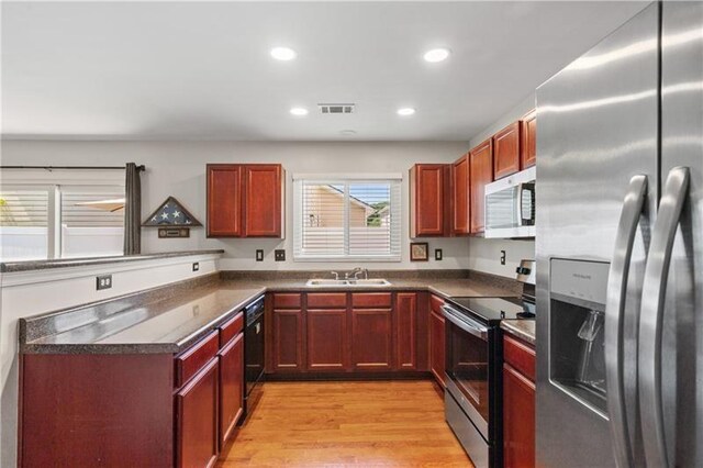 kitchen featuring appliances with stainless steel finishes, light hardwood / wood-style floors, and sink