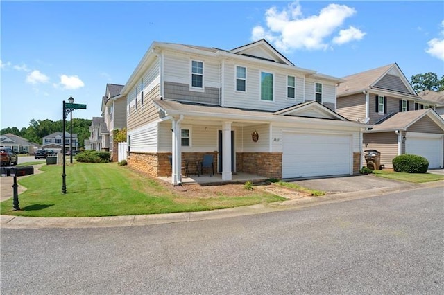 view of front of home with a front lawn, covered porch, and a garage