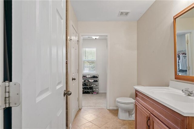 bathroom with tile patterned flooring, vanity, and toilet