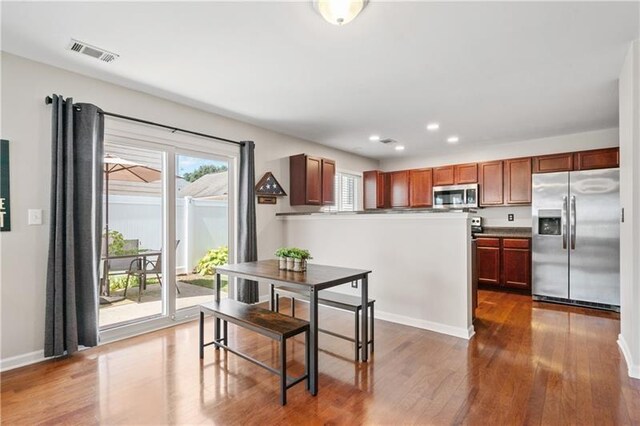 kitchen with stainless steel appliances and dark hardwood / wood-style floors