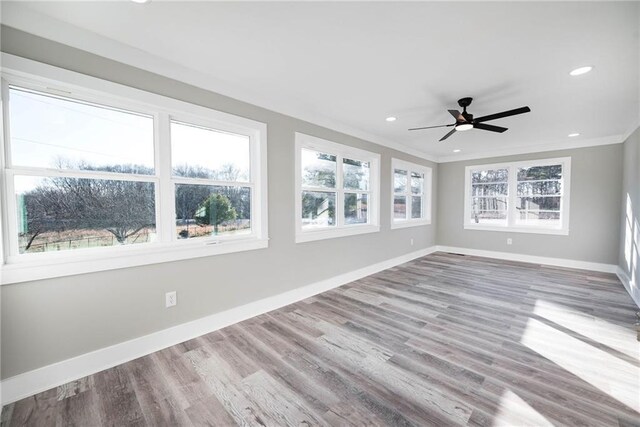 unfurnished sunroom with ceiling fan