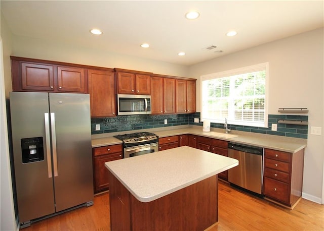 942 Idlewood Dr, Canton, GA 30115 - kitchen featuring stainless steel appliances, a sink, light wood finished floors, backsplash, and light countertops