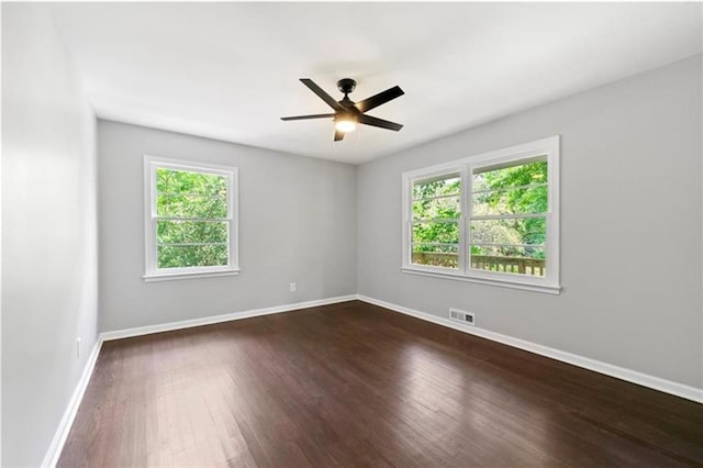 unfurnished room with ceiling fan and dark wood-type flooring