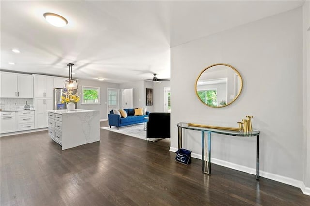 kitchen featuring backsplash, hanging light fixtures, ceiling fan, dark hardwood / wood-style flooring, and white cabinetry