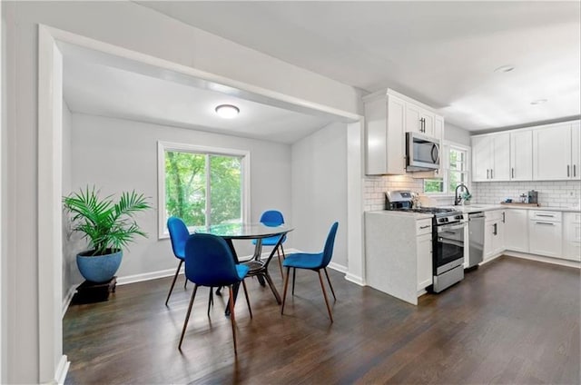 kitchen featuring sink, stainless steel appliances, backsplash, plenty of natural light, and white cabinets