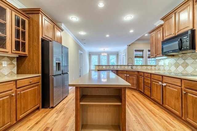 980 Windsor Place Cir, Grayson, GA 30017 - kitchen with black appliances, ornamental molding, a sink, light wood-style flooring, and a peninsula