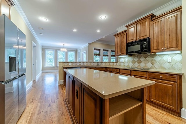 980 Windsor Place Cir, Grayson, GA 30017 - kitchen featuring black appliances, crown molding, a peninsula, brown cabinetry, and light wood finished floors
