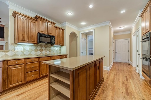 980 Windsor Place Cir, Grayson, GA 30017 - kitchen with black appliances, brown cabinets, arched walkways, light wood finished floors, and ornamental molding