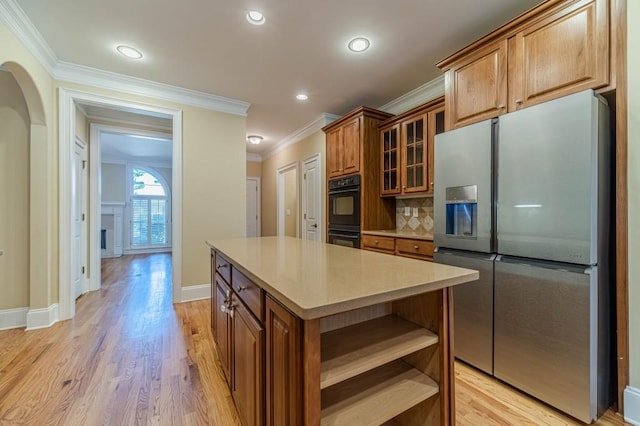 980 Windsor Place Cir, Grayson, GA 30017 - kitchen with stainless steel fridge, open shelves, brown cabinetry, backsplash, and crown molding