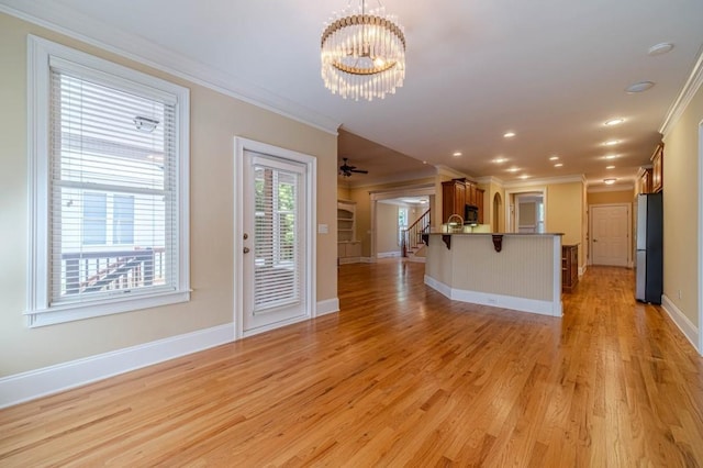 980 Windsor Place Cir, Grayson, GA 30017 - unfurnished living room featuring crown molding, a chandelier, light wood finished floors, baseboards, and stairs