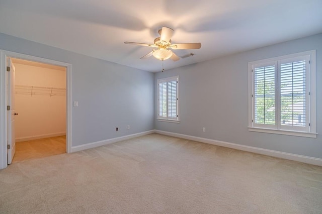 980 Windsor Place Cir, Grayson, GA 30017 - unfurnished bedroom featuring light carpet, baseboards, a walk in closet, and a ceiling fan