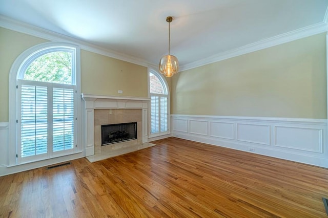 980 Windsor Place Cir, Grayson, GA 30017 - unfurnished living room featuring crown molding, a fireplace, wood finished floors, a wainscoted wall, and a decorative wall