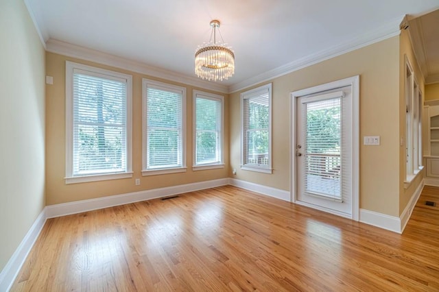 980 Windsor Place Cir, Grayson, GA 30017 - unfurnished dining area with a chandelier, crown molding, baseboards, and light wood-style flooring