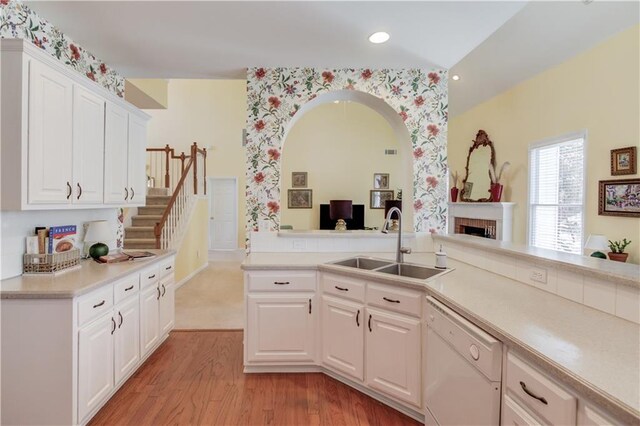 kitchen with sink, white cabinets, dishwasher, and light wood-type flooring