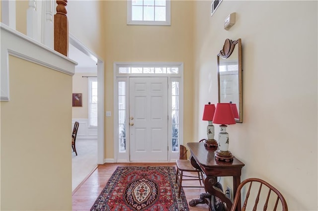 foyer with a high ceiling and light hardwood / wood-style floors