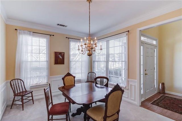 dining area with crown molding, a chandelier, and a wealth of natural light