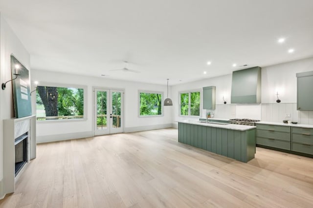 2760 Fraser St SE, Smyrna, GA 30080 - kitchen featuring green cabinetry, wall chimney exhaust hood, a sink, ceiling fan, and light wood-style floors