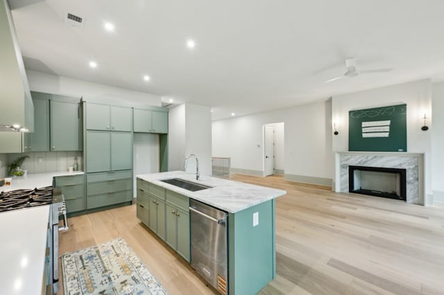 2760 Fraser St SE, Smyrna, GA 30080 - kitchen with green cabinetry, stainless steel appliances, a sink, range hood, and light wood-style flooring