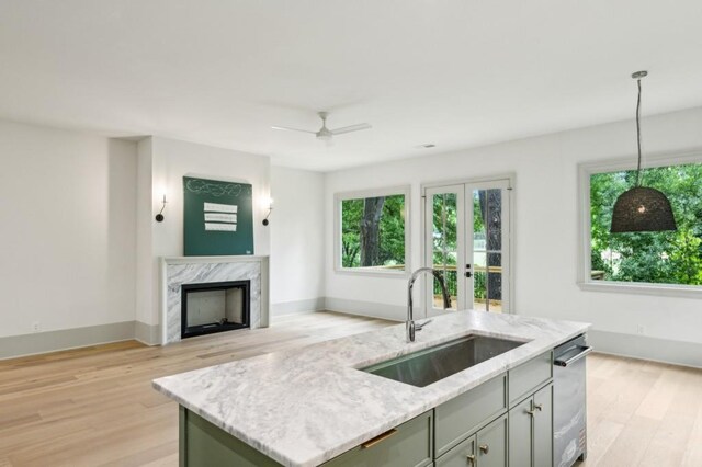 2760 Fraser St SE, Smyrna, GA 30080 - kitchen featuring a sink, light wood-style flooring, light stone counters, an island with sink, and open floor plan