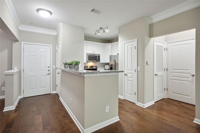 kitchen with light stone countertops, stainless steel appliances, white cabinetry, and dark hardwood / wood-style floors