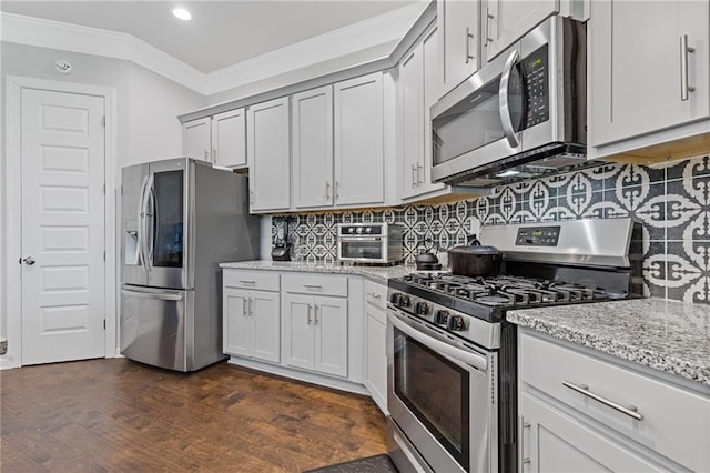 kitchen featuring light stone counters, dark wood-style floors, ornamental molding, stainless steel appliances, and tasteful backsplash