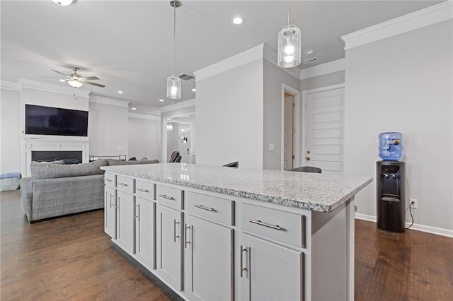 kitchen featuring decorative light fixtures, baseboards, dark wood-type flooring, and a fireplace