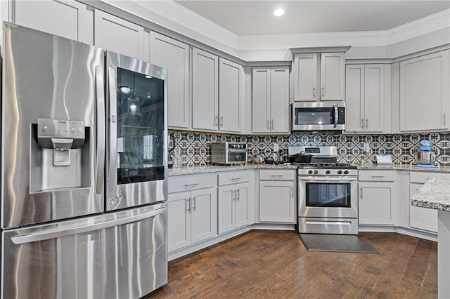 kitchen featuring ornamental molding, tasteful backsplash, dark wood-style floors, stainless steel appliances, and light stone countertops