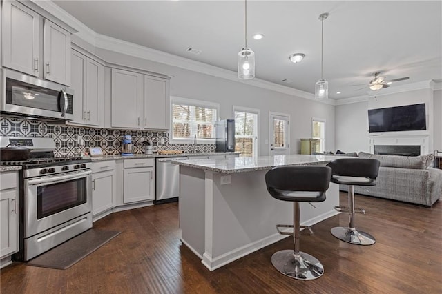 kitchen featuring visible vents, open floor plan, ornamental molding, decorative backsplash, and appliances with stainless steel finishes