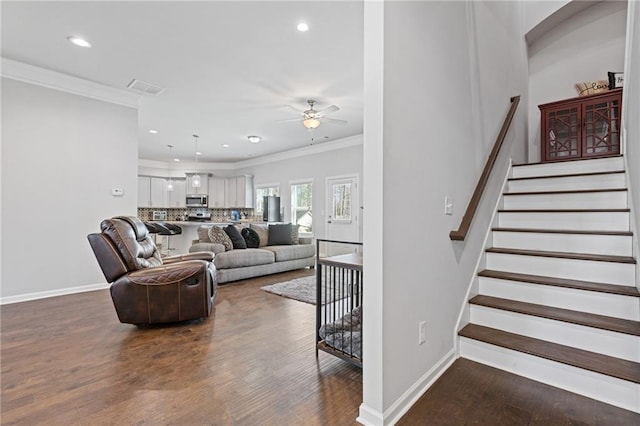 living room with visible vents, crown molding, baseboards, dark wood-style floors, and a ceiling fan