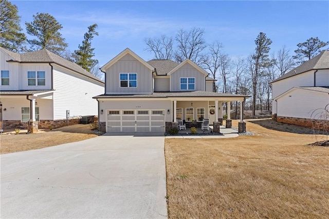 view of front of home featuring a porch, concrete driveway, a front lawn, a garage, and board and batten siding