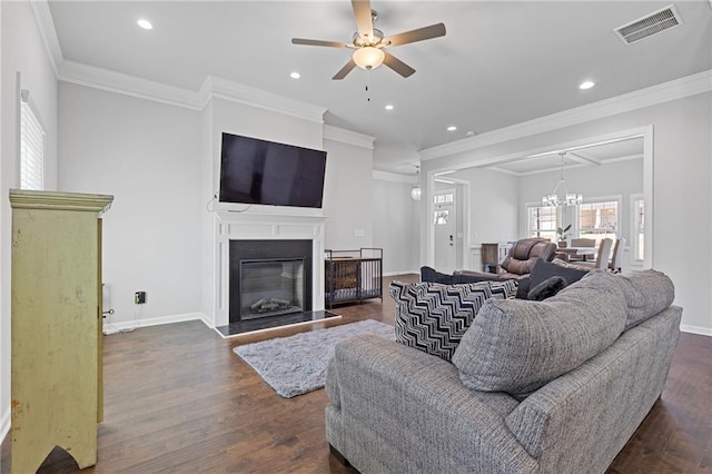 living room featuring a glass covered fireplace, dark wood-type flooring, baseboards, and visible vents