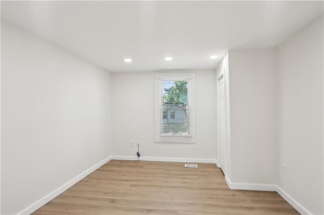 unfurnished room with light wood-style floors, baseboards, recessed lighting, and visible vents