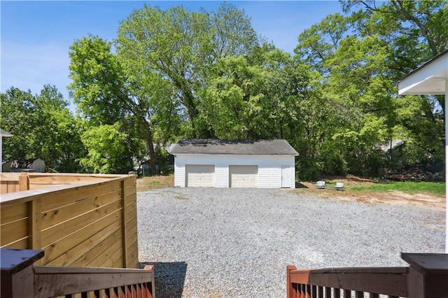 view of yard featuring a garage and an outbuilding