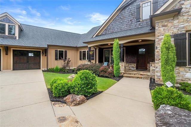 49 Waterside Dr SE, Cartersville, GA 30121 - entrance to property featuring board and batten siding, covered porch, concrete driveway, a garage, and stone siding