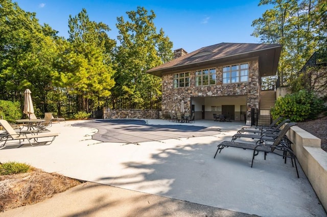 49 Waterside Dr SE, Cartersville, GA 30121 - rear view of property with stone siding, a patio area, and a chimney