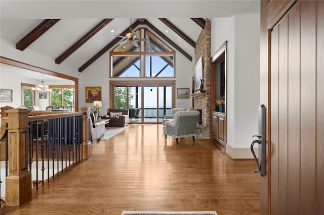 49 Waterside Dr SE, Cartersville, GA 30121 - living area with beamed ceiling, a chandelier, light wood finished floors, a stone fireplace, and high vaulted ceiling