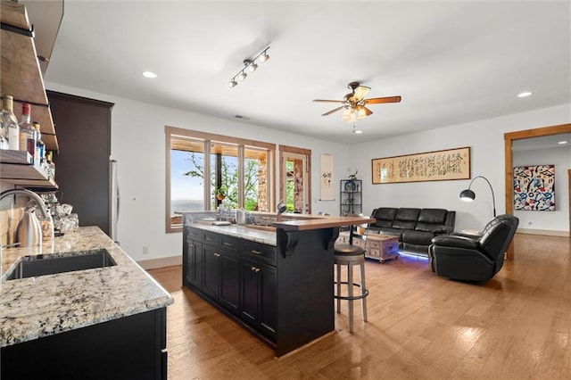49 Waterside Dr SE, Cartersville, GA 30121 - kitchen featuring ceiling fan, a breakfast bar, wood finished floors, recessed lighting, and dark cabinets