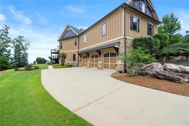 49 Waterside Dr SE, Cartersville, GA 30121 - view of front facade featuring stone siding, board and batten siding, driveway, an attached garage, and a front lawn